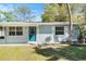 Close-up of a tidy single-story home with a blue front door and light grey exterior at 4421 W Iowa Ave, Tampa, FL 33616