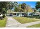 Charming home featuring a well-manicured lawn and a vibrant blue front door at 4421 W Iowa Ave, Tampa, FL 33616