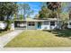 Well-maintained single-story home featuring a tidy front lawn and a screened-in porch at 4421 W Iowa Ave, Tampa, FL 33616