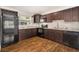 Modern kitchen featuring dark wood cabinets, granite countertops, and stainless steel appliances at 4421 W Iowa Ave, Tampa, FL 33616