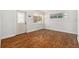 Inviting living room with gleaming wood floors, a front door, and a sun-filled window at 4421 W Iowa Ave, Tampa, FL 33616
