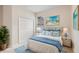 Bright bedroom featuring blue accents, beach-themed artwork, and a comfortable wicker bed frame at 4515 Fieldview Cir, Wesley Chapel, FL 33545