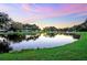 Scenic view of the tranquil pond reflecting the colorful sky at sunset, a serene community setting at 5350 Mohawk St, Zephyrhills, FL 33542