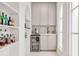 Bar area with mini fridge, grey cabinets, tile backsplash and nearby open shelving at 54 Aegean Ave, Tampa, FL 33606