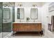 Modern bathroom with a wood vanity, double sinks, mirrors and a glass-enclosed shower at 54 Aegean Ave, Tampa, FL 33606