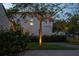 Beautiful stucco home at twilight featuring mature landscaping and stylish outdoor lighting at 54 Aegean Ave, Tampa, FL 33606