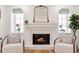 Cozy fireplace with white mantel, arched windows, and comfortable chairs, creating an inviting and relaxing atmosphere at 54 Aegean Ave, Tampa, FL 33606