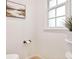 Bright powder room features a pedestal sink, modern toilet, and a framed scenic artwork at 54 Aegean Ave, Tampa, FL 33606