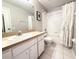 Well-lit bathroom featuring a vanity with a sink, toilet, and shower with tub at 5702 War Admiral Dr, Wesley Chapel, FL 33544