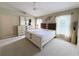 Bright bedroom featuring a king bed, ceiling fan, and large windows for natural light at 5702 War Admiral Dr, Wesley Chapel, FL 33544