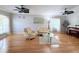 Spacious living room showcasing wood floors, neutral paint, ceiling fans and comfortable seating at 5702 War Admiral Dr, Wesley Chapel, FL 33544