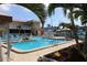 Inviting community pool surrounded by lounge chairs, covered seating, and tropical plants at 5935 30Th S Ave # 204, Gulfport, FL 33707
