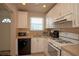 Cozy kitchen featuring white cabinets, appliances, and a window with neighborhood views at 5935 30Th S Ave # 204, Gulfport, FL 33707