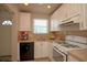 Compact kitchen features white cabinets, essential appliances, tiled countertops and backsplash at 5935 30Th S Ave # 204, Gulfport, FL 33707