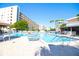 Bright and spacious community pool area featuring multiple lounge chairs, umbrellas, and well-maintained landscaping at 5935 30Th S Ave # 204, Gulfport, FL 33707