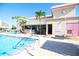 Community pool area featuring palm trees, sun loungers, a restroom, and pristine turquoise water at 5935 30Th S Ave # 204, Gulfport, FL 33707