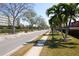A tranquil street view shows a sidewalk lined with palm trees and lush landscaping near the complex at 5935 30Th S Ave # 204, Gulfport, FL 33707
