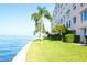 Scenic waterfront view with palm trees lining the property, and a multi-story building at 5935 30Th S Ave # 204, Gulfport, FL 33707
