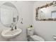 Charming powder room with unique seashell-themed mirrors, toilet, and decorative accents at 6239 French Creek Ct, Ellenton, FL 34222