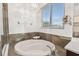 Bathroom featuring a luxurious soaking tub under a bright window and tiled surround at 6239 French Creek Ct, Ellenton, FL 34222