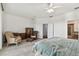 Bright bedroom with carpet, ceiling fan, and furniture; open doors lead to the bathroom at 6239 French Creek Ct, Ellenton, FL 34222