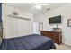Bright bedroom features a neutral palette, ceiling fan, mounted TV, and closet at 6239 French Creek Ct, Ellenton, FL 34222