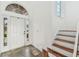 Bright foyer with white front door, tile flooring, and staircase at 6239 French Creek Ct, Ellenton, FL 34222
