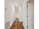 Hallway featuring hardwood floors, white trim, and access to many rooms at 6239 French Creek Ct, Ellenton, FL 34222