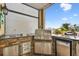 The outdoor grilling area features a stainless steel grill, sink, fridge, and bar seating at 6239 French Creek Ct, Ellenton, FL 34222