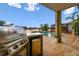 Outdoor grilling area overlooking the pool features a stainless steel grill, sink, and fridge at 6239 French Creek Ct, Ellenton, FL 34222