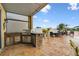 Outdoor kitchen with stainless steel grill and sink, stone accents, and views of the lake at 6239 French Creek Ct, Ellenton, FL 34222