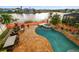 Aerial view of a pool and spa with a lake view; outdoor seating and lush landscaping are shown at 6239 French Creek Ct, Ellenton, FL 34222