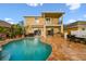 A gorgeous pool and spa combo, an outdoor kitchen, and a two-story patio with sliding doors at 6239 French Creek Ct, Ellenton, FL 34222