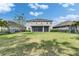 Expansive fenced backyard with lush lawn, screened patio, and beautiful landscaping at 6423 Seasound Dr, Apollo Beach, FL 33572