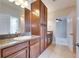 Bathroom featuring double vanity with granite counters and wood cabinets at 6423 Seasound Dr, Apollo Beach, FL 33572
