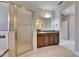 A well-lit bathroom with a granite countertop vanity, framed mirror, and a glass-enclosed shower for relaxation and convenience at 6423 Seasound Dr, Apollo Beach, FL 33572