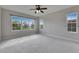 Spacious bedroom features carpet flooring, neutral paint, ceiling fan, and large windows for natural light at 6423 Seasound Dr, Apollo Beach, FL 33572