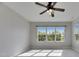 A carpeted bedroom filled with natural light from a large window and modern ceiling fan at 6423 Seasound Dr, Apollo Beach, FL 33572