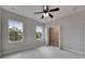 Well-lit bedroom with carpet, ceiling fan, and two windows providing outdoor views and natural light at 6423 Seasound Dr, Apollo Beach, FL 33572
