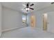 Bright bedroom features neutral decor, carpet floors, ceiling fan, and access to an ensuite bathroom at 6423 Seasound Dr, Apollo Beach, FL 33572