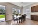 Elegant dining room with a large window, dining table, and modern light fixture at 6423 Seasound Dr, Apollo Beach, FL 33572