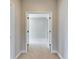 Hallway view into a bedroom, showcasing neutral decor, carpet flooring, and natural light at 6423 Seasound Dr, Apollo Beach, FL 33572