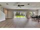 Expansive living room with wood-look floors and sliding glass doors opening to the backyard at 6423 Seasound Dr, Apollo Beach, FL 33572