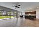 Spacious living room featuring a ceiling fan, hardwood floors, and sliding glass doors overlooking the backyard at 6423 Seasound Dr, Apollo Beach, FL 33572