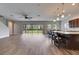 Open-concept living area featuring wood-look floors, kitchen with bar seating, and backyard view at 6423 Seasound Dr, Apollo Beach, FL 33572