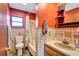 Bathroom with orange walls, checkered tile, sink, toilet, and shower at 6501 62Nd N St, Pinellas Park, FL 33781