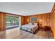 Bedroom with wood paneled walls, wood look flooring, and a sliding door to deck at 6501 62Nd N St, Pinellas Park, FL 33781