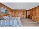 Bedroom with wood paneled walls, wood look flooring, large bed, and closet at 6501 62Nd N St, Pinellas Park, FL 33781