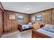 Bedroom with wood paneled walls, wood look flooring, and 2 twin beds at 6501 62Nd N St, Pinellas Park, FL 33781
