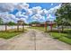 Long concrete driveway leads to a charming rural home with a red-framed gate and well-maintained front yard at 6501 62Nd N St, Pinellas Park, FL 33781